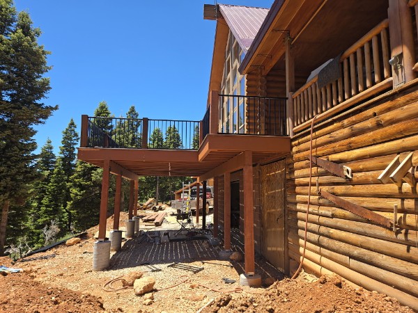Later deck with black railing installed at log cabin.